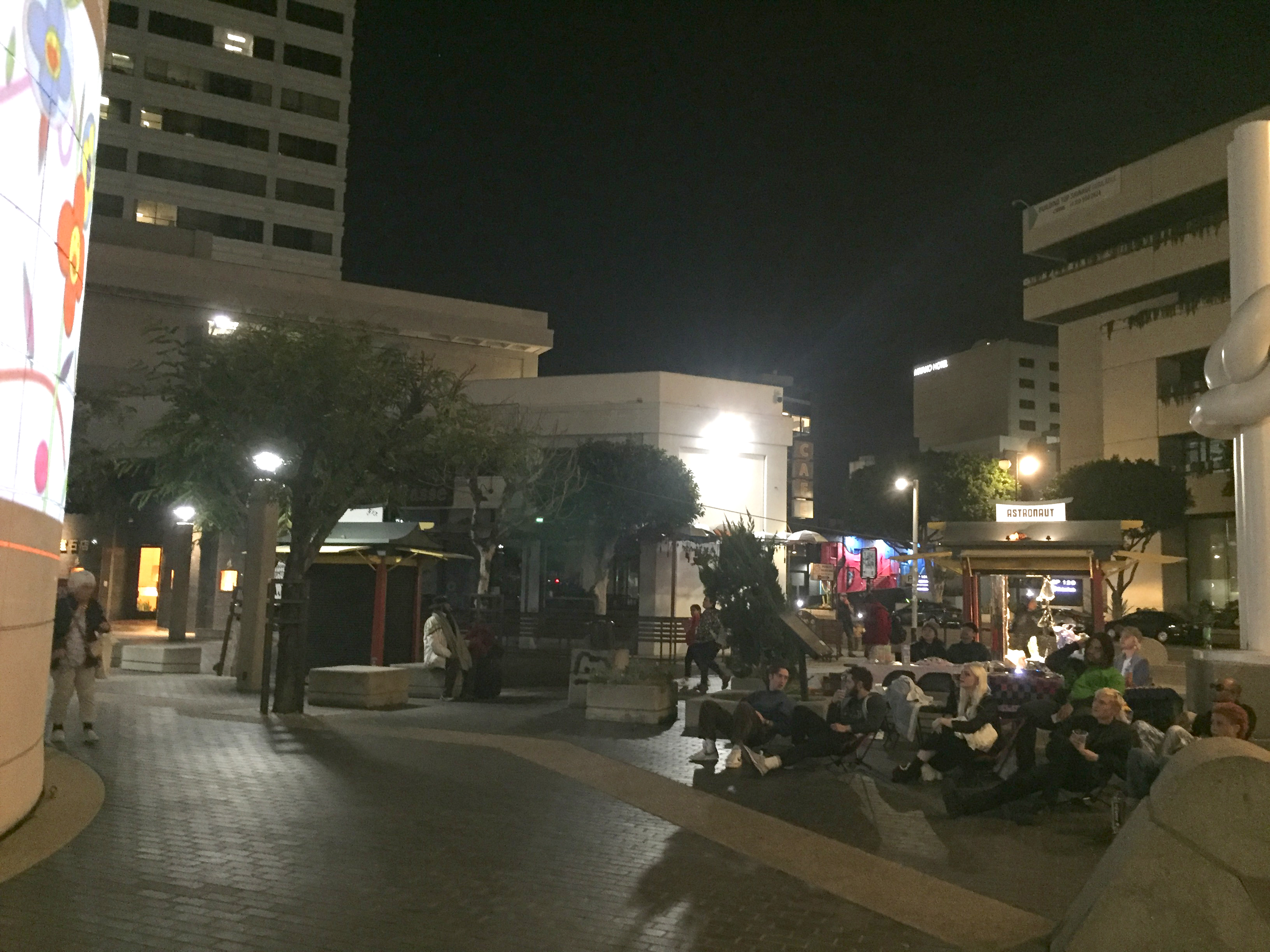 A crowd of people watching a projection on a building